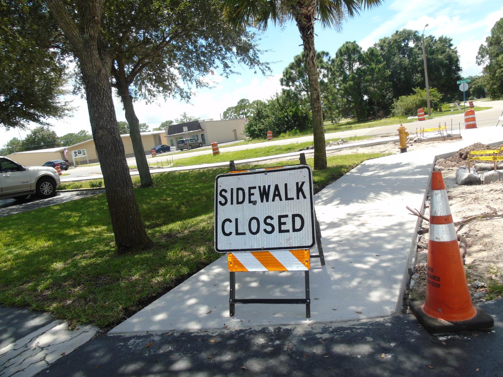 Sidewalk being repaired with a sidewalk close sign